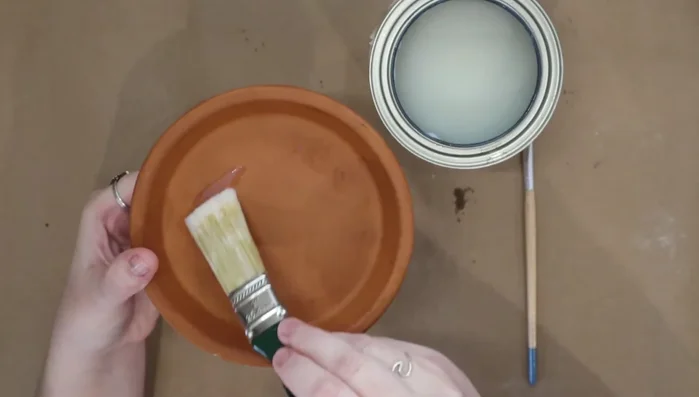 Use a smaller brush to paint the sides and lip of the pot, paying attention to detail.