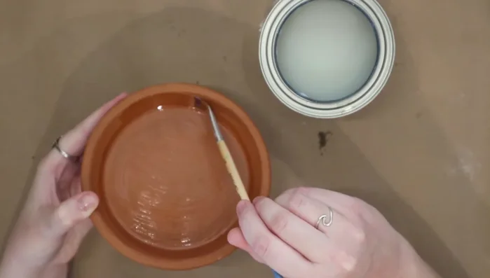 Use a smaller brush to paint the sides and lip of the pot, paying attention to detail.
