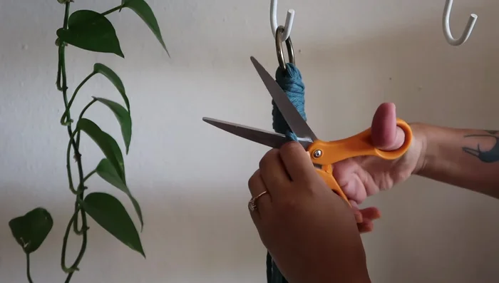 Carefully cut off the excess strands from the gathering knot.