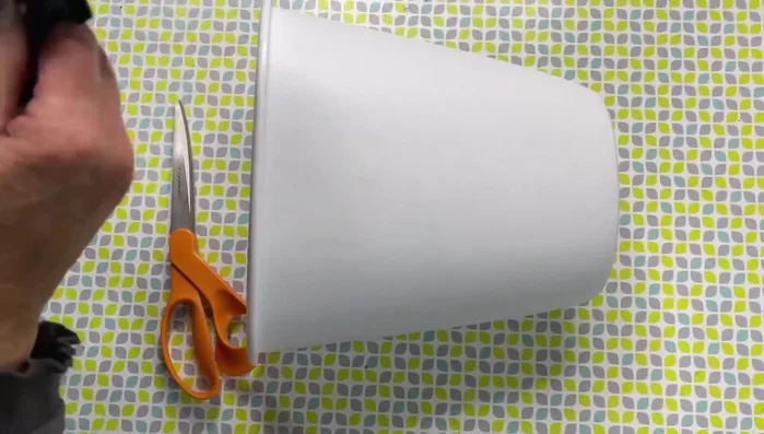 Measure and cut the pant fabric to fit the trash can's circumference.