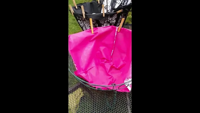 Lay the bag into the basket, covering one half. Secure it with safety pins.
