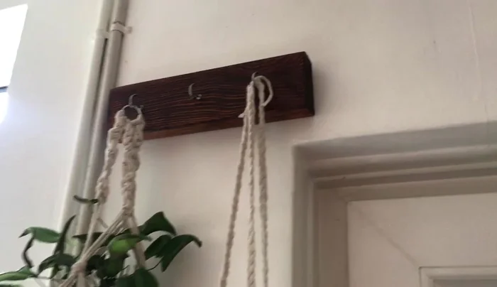 Construct a wooden hook using IKEA bed slats and screw-in hooks.