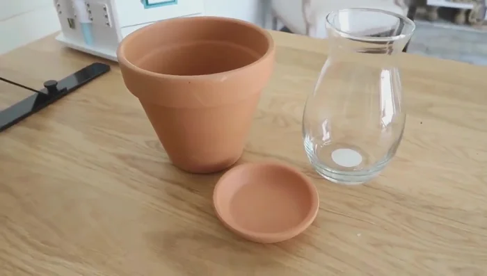 Construct a terracotta pot lantern by adding stuffing, a small saucer, a Dollar Tree vase, river rocks and a votive candle.