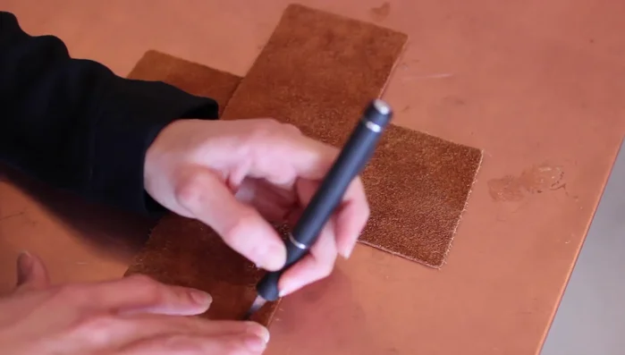 Use an X-acto knife to make an X-shaped hole in each corner of the leather pieces.