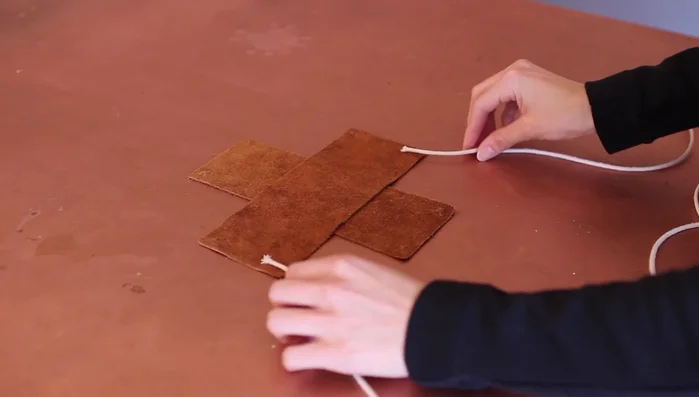 Repeat step 3 with a second cord on the opposite side of the same leather piece.